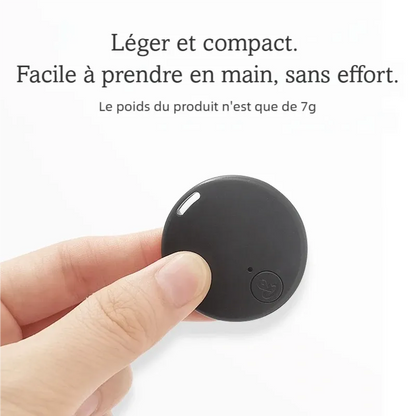 Traceur Bluetooth anti-perte noir tenu entre le pouce et l'index, illustrant sa taille compacte et son poids de 7 g indiqué par le texte visible, bouton central et LED visibles.